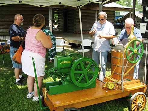Visitors to Baker Memories Day enjoy fresh, homemade ice cream churned by Baker Block Museum volunteer Jerry Champion, right.