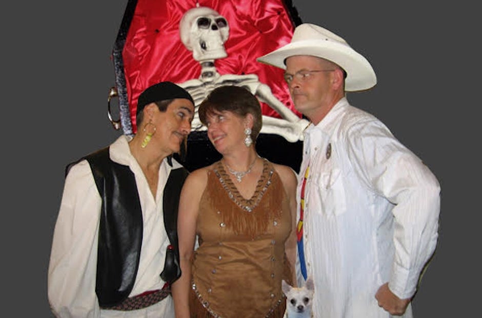 "Murder at the Monster Bash" cast members portray, from left, Conner Crump (actor Joe Chase), Ivana Crump (Kay Yarbrough) and Clark Crump (Chris Manson). They are pictured with Chablis the Wonder Dog. [PAULA HILTON | SPECIAL TO THE NEWS BULLETIN]