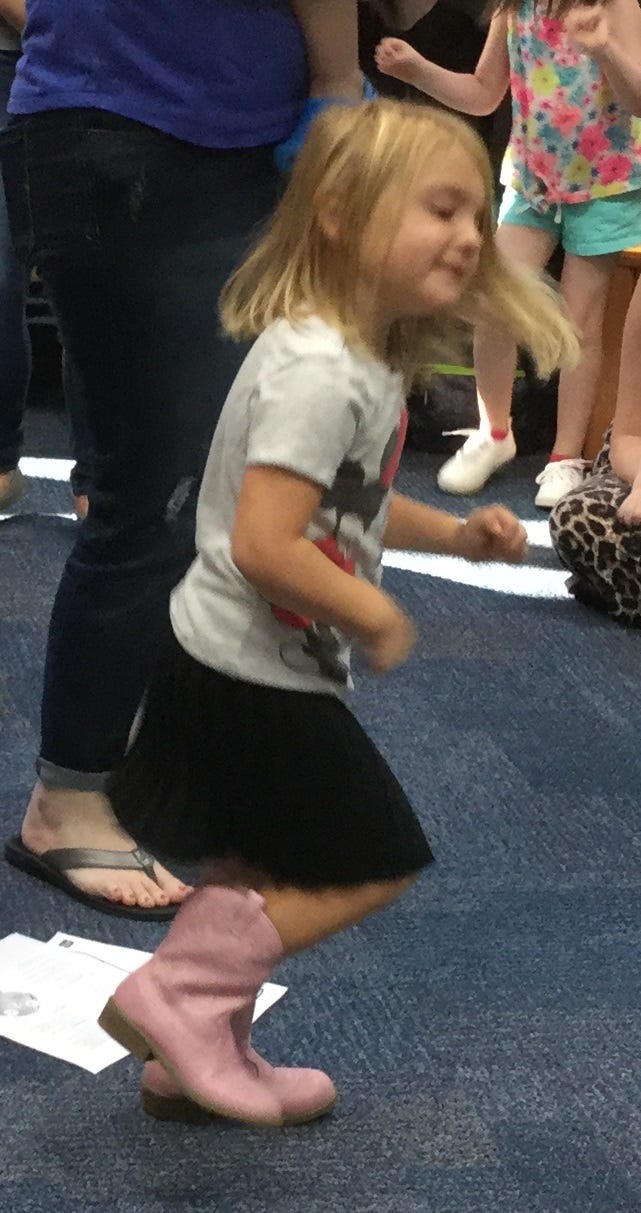 Penelope Reinhardt, 3, a resident of Crestview, marches to the drum recently in Library Class at the Crestview Public Library. [Special to the News Bulletin]