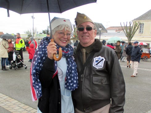 Crestview residents Pam and Joe Coffield, costumed as a World War II-era American field nurse and Maj. Pappy Boyington, leader of the "Black Sheep Squadron," respectively, shelter under an umbrella last weekend as a light rain falls on the Noirmoutier Place d'Arms. The Coffields joined Crestview's delegation on the French island of Noirmoutier, where they helped celebrate the 70th anniversary of France's liberation at the end of World War II.
