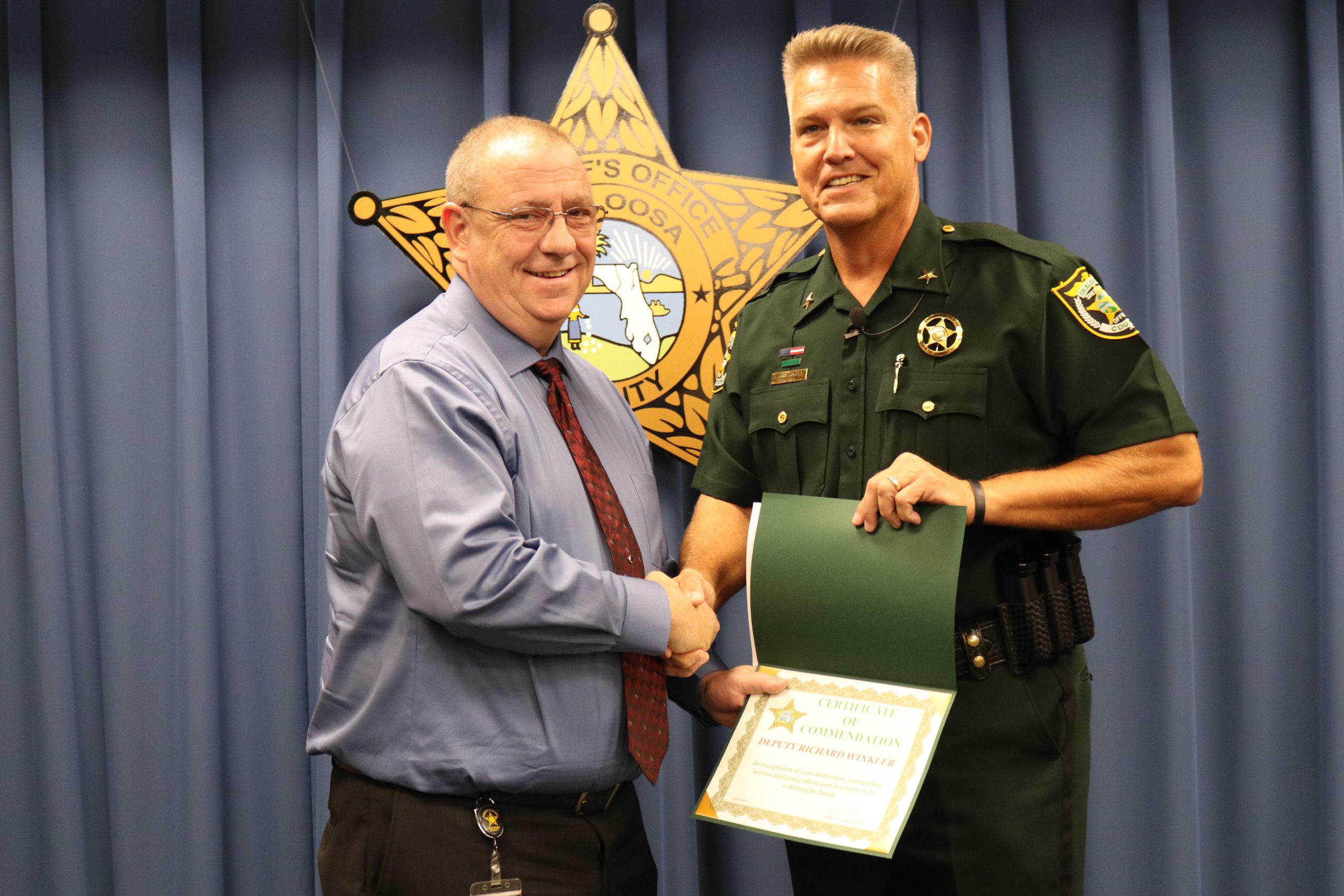On April 2, the Airport Security Unit was notified that an eight-month-old child had fallen out of a carrier worn by the mother and hit his head on the tile floor in the bathroom. Okaloosa County Sheriff deputy Richard Winkler made contact with the mother who was extremely distraught and fearful that her baby was seriously injured. Winkler examined the baby’s head and noticed a visible injury and summoned Eglin Air Force Base EMS. He then volunteered to care for the baby until the mother could gather her composure, which also allowed him to monitor the baby’s behavior until EMS arrived. The baby’s father arrived and EMS transported the baby to the hospital. Winkler remained with the mother at the airport to assist with the care of her other baby and help get the family’s luggage from the airline. Winkler’s caring personality and selfless actions were very appreciated by the family during this emotional time. He went above and beyond to assist them in their time of need and for his actions he was presented with the OCSO Certificate of Commendation.
