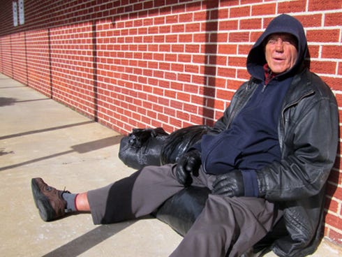 Jimmy James, a homeless man from Arizona, rests next to the First Presbyterian Church of Crestview Friday afternoon while awaiting the church’s evening cold weather shelter’s opening.