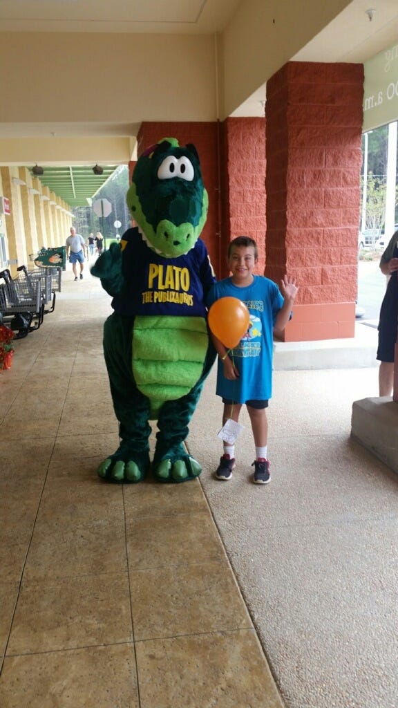 Jordan Justiss stands with Publix store mascot Plato Nov. 8 in Crestview. [SPECIAL TO THE NEWS BULLETIN]