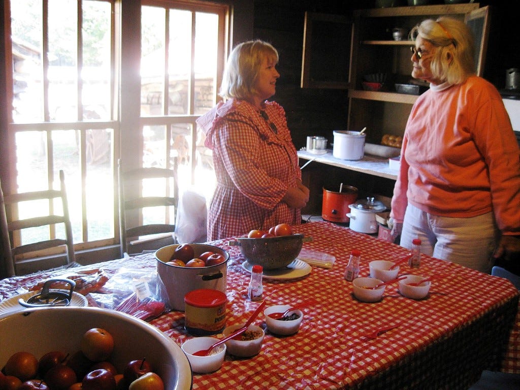 Lillian Van Houten, right, chats with historic re-enactor Cindy Bronson in the Baker Block Museum’s dog-trot house. Van Houten’s mother was born in the home.