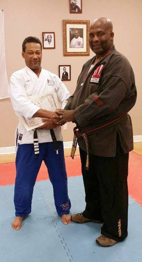 Regie Toussaint, co-owner of USA Karate Academy in Crestview, accepts his eighth-degree black belt from Professor Gallop Franklin (right), of the Gallop Karate Center in Tallahassee. [SPECIAL TO THE NEWS BULLETIN]