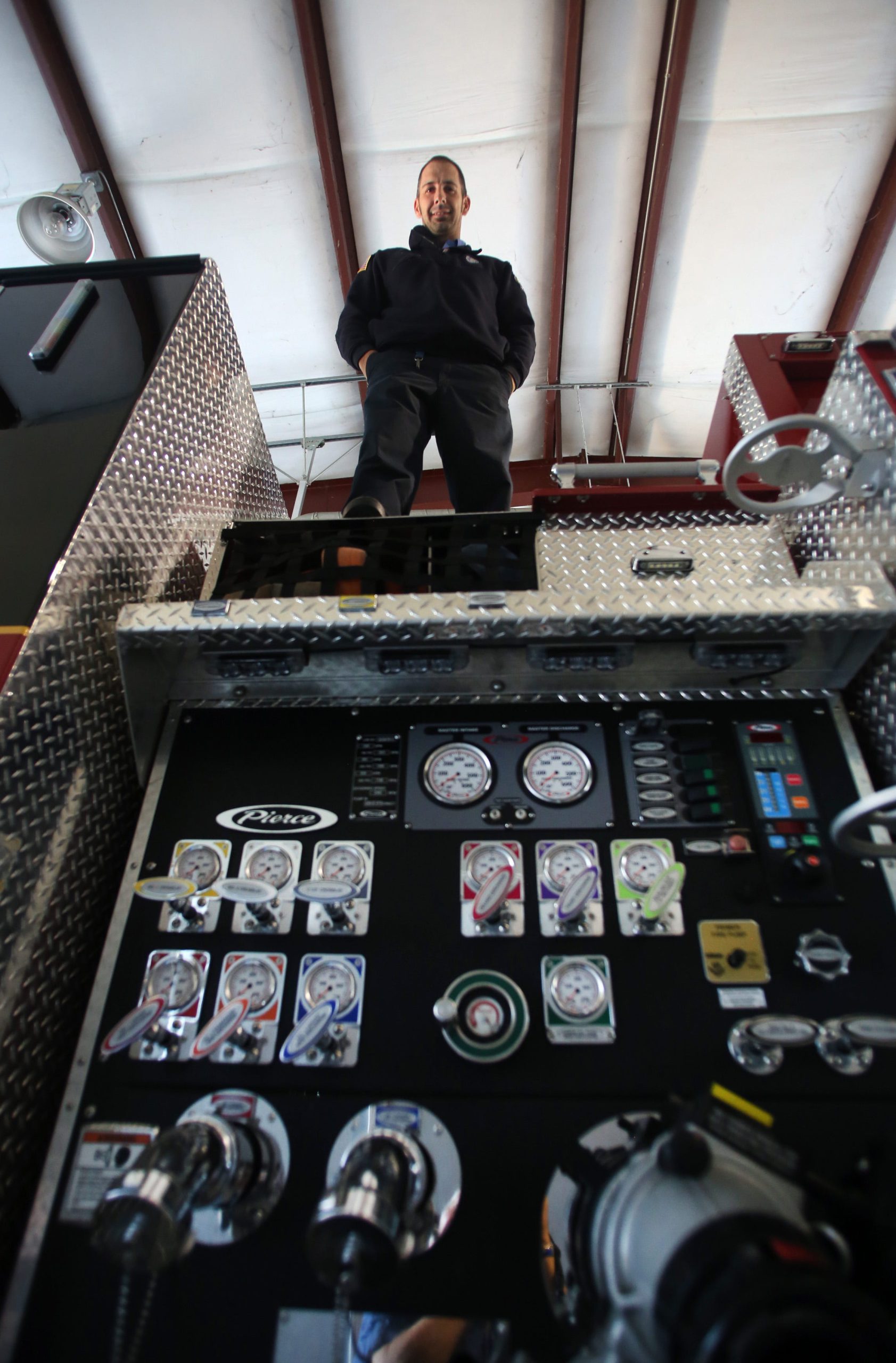 Crestview Fire Captain David Turnage stands atop his station's engine. Turnage nearly lost his right leg to an infection that occurred following a routine training exercise. [MICHAEL SNYDER/DAILY NEWS]