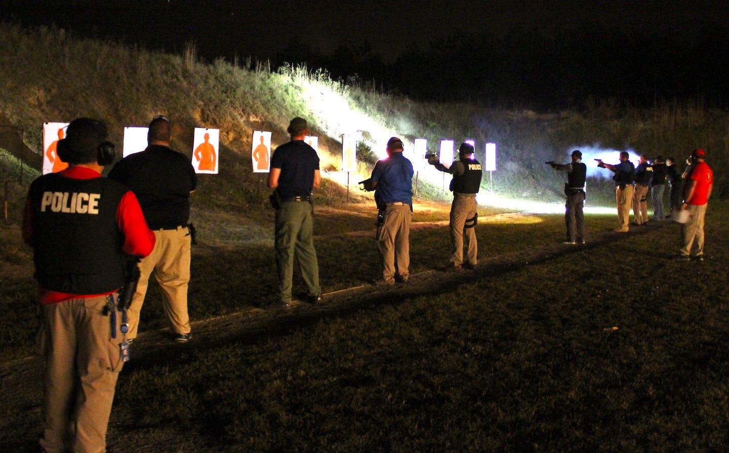 With firing range lighting completely extinguished, Crestview police officers practice nighttime shooting, providing their own illumination with flashlights or lights clamped to their weapon barrels. [BRIAN HUGHES | Crestview Police Department]