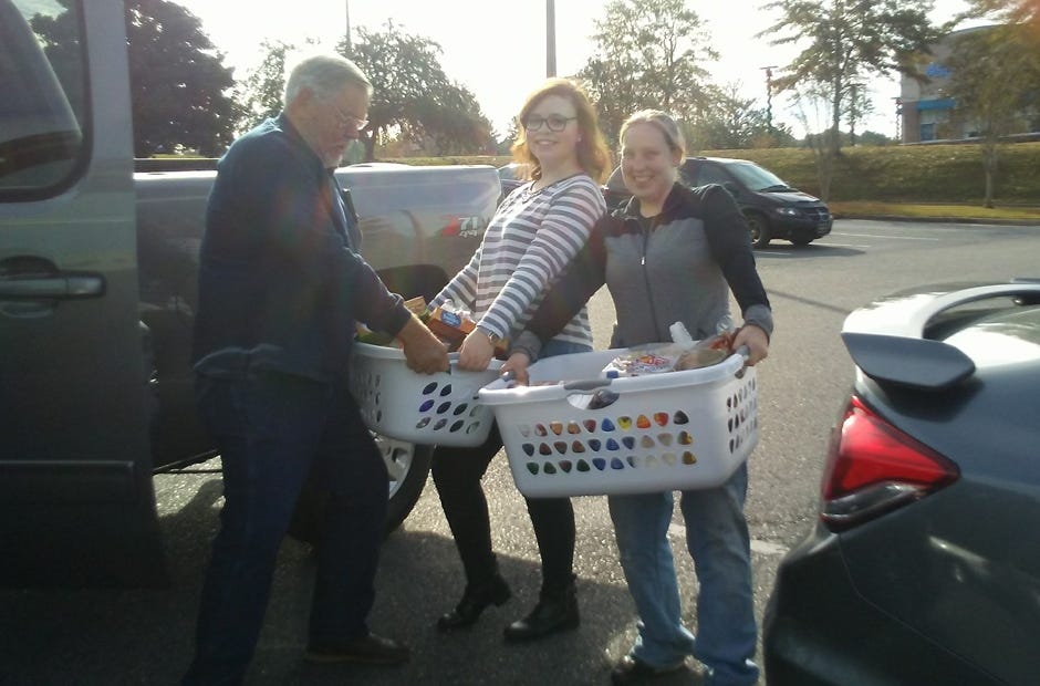Emerald Coast Hospice volunteer Jim Griffin of Crestview accepts Thanksgiving grocery supplies from Pentecostals of Baker Church representatives Jessica Bray and Ann Hicks (right). The church donated 10 complete Thanksgiving dinners to ECH patients. [SPECIAL TO THE NEWS BULLETIN]