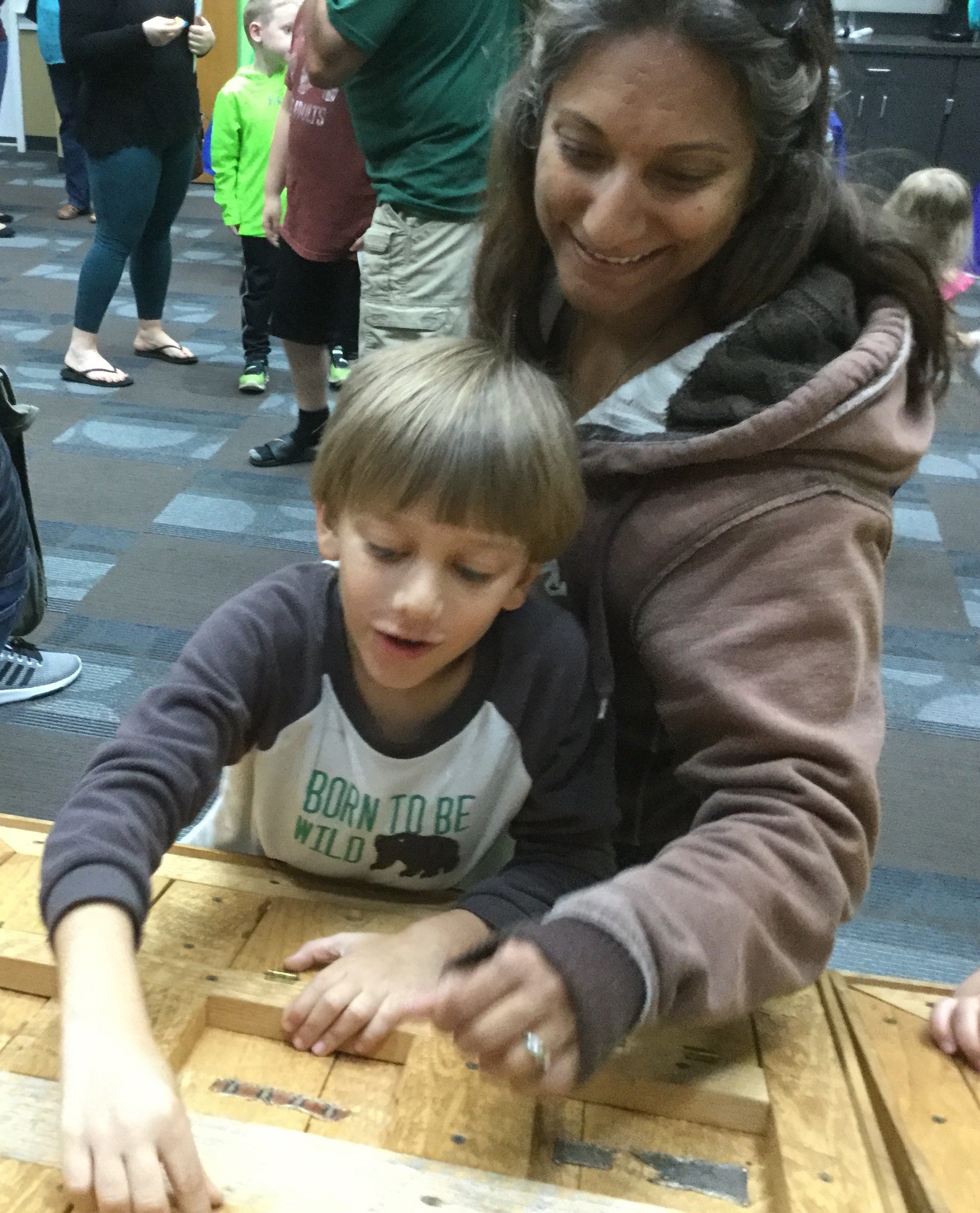 Ishaan, age 6, and Amy Overfield, both residents of Crestview, guess which animal belongs to this skin during a recent event at the Crestview Public Library. [SPECIAL TO THE NEWS BULLETIN]