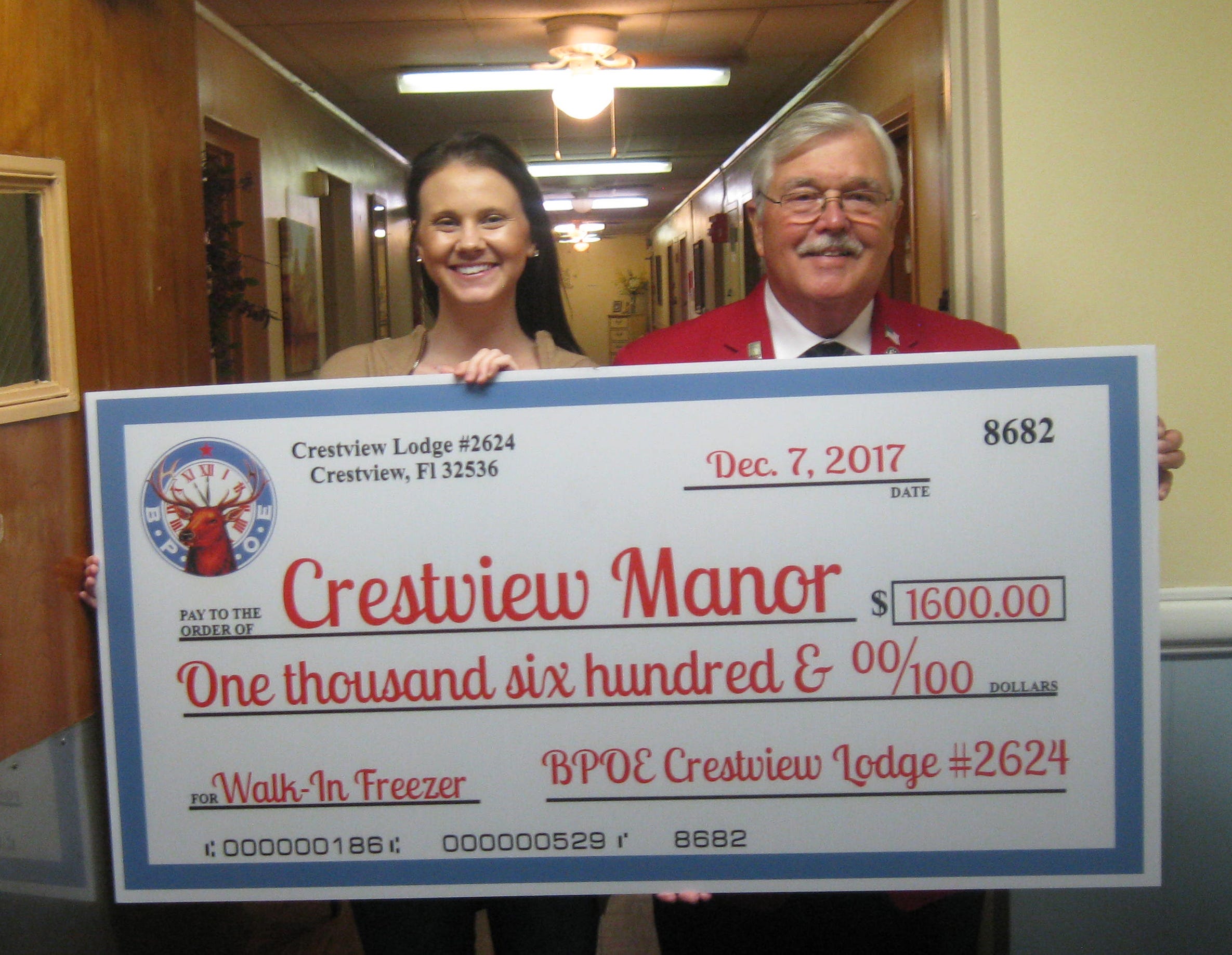Crestview Elks Lodge 2624 members donated funds toward the repair of a walk-in freezer to Crestview Manor, an assisted living facility on North Pearl Street in Crestview. Keely McNeal, resident care coordinator, accepts a check from the lodge's Exalted Ruler, Bob Daniel, Wednesday at the facility. [RENEE BELL | NEWS BULLETIN]
