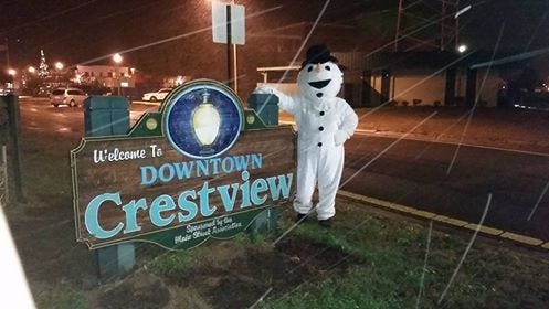 Eileen Malaca Magalianes contributed this photo of snow falling near a downtown Crestview sign. [Special to the News Bulletin]