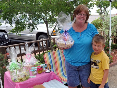 Pam Pursley stands beside her grandson, Zane Murrell, 7, at her tent on Friday at Main Street’s curbside market. Pursley wants to raise awareness for lupus, a painful autoimmune disease that she was diagnosed with more than two years ago.