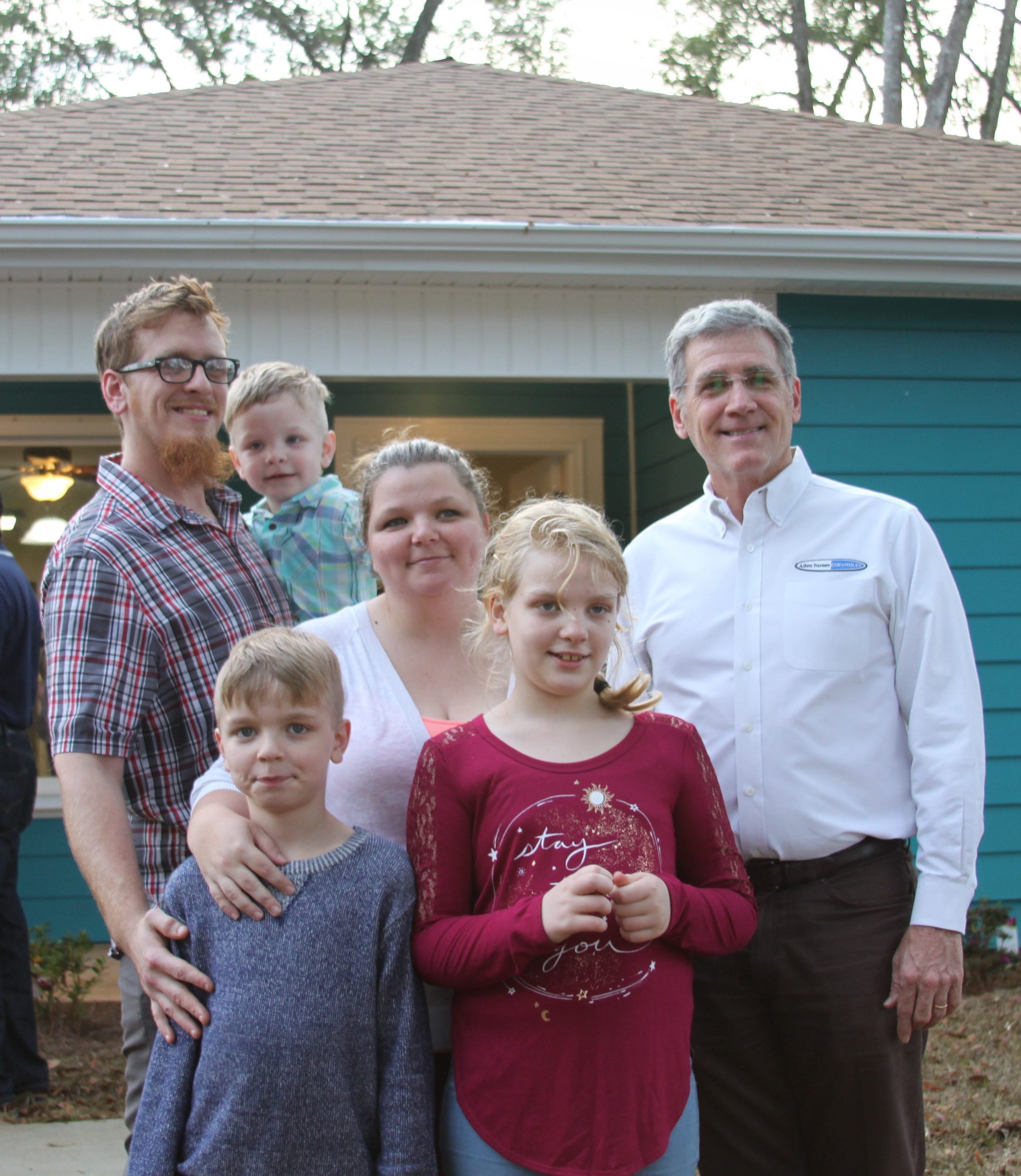 Joshua and Jessica Ruckowski, and their three children, Lawson (back row), Ledger and Lola, stand with their home's sponsor, Allen Turner of Allen Turner Chevrolet. [ANGEL MCCARTY | HABITAT FOR HUMANITY-OKALOOSA]