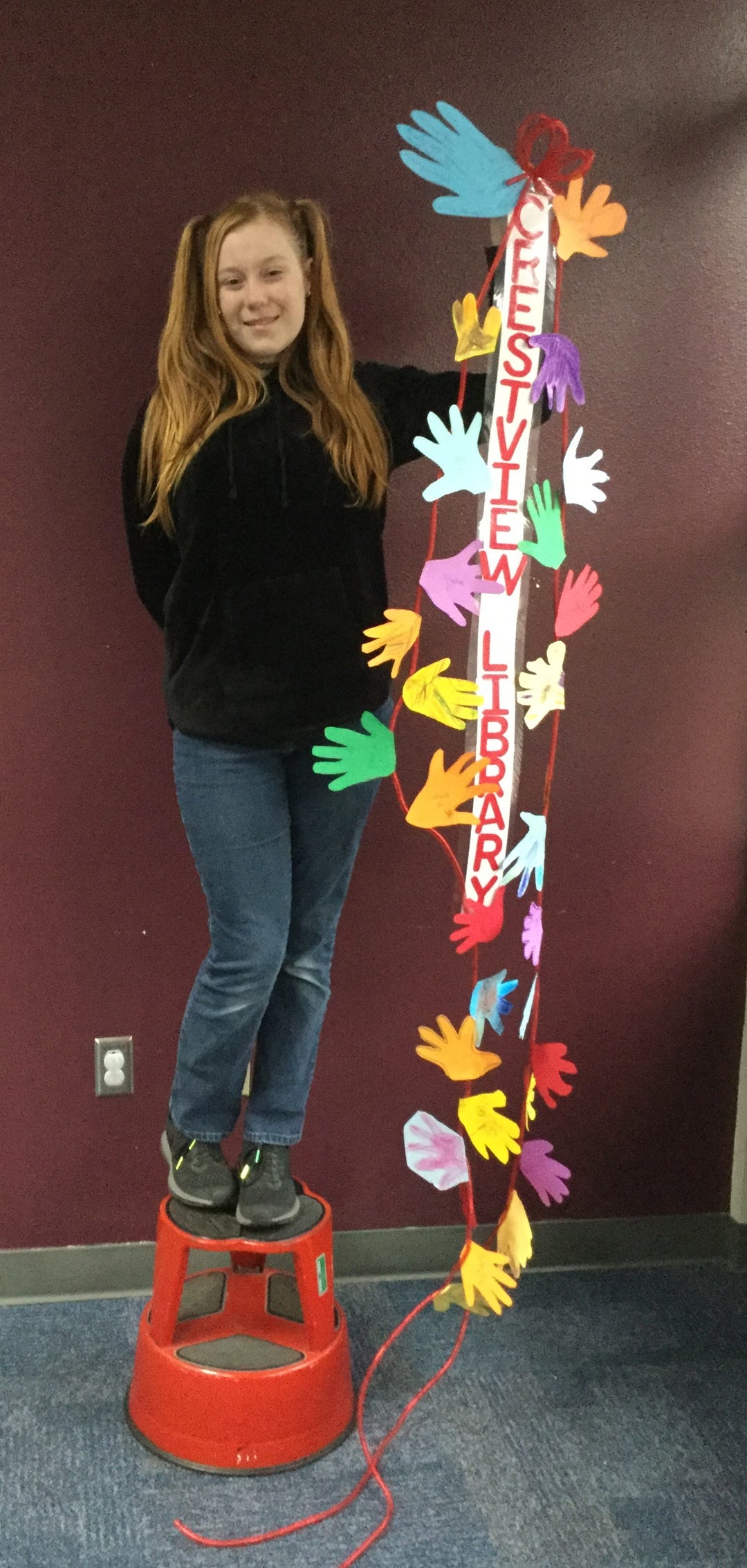 Allison Banks, 13, displays decorative hands that kids in the Ages 3-5 Library Class made Jan. 9 at the Crestview Public Library. The hands will be hung in the state capitol, along with many others, during Children's Week, Jan. 21-26 in Tallahassee, to remind legislators and advocates that "we must take care of our most precious commodity, our children," a library media release states. [HEATHER NITZEL | SPECIAL TO THE NEWS BULLETIN]