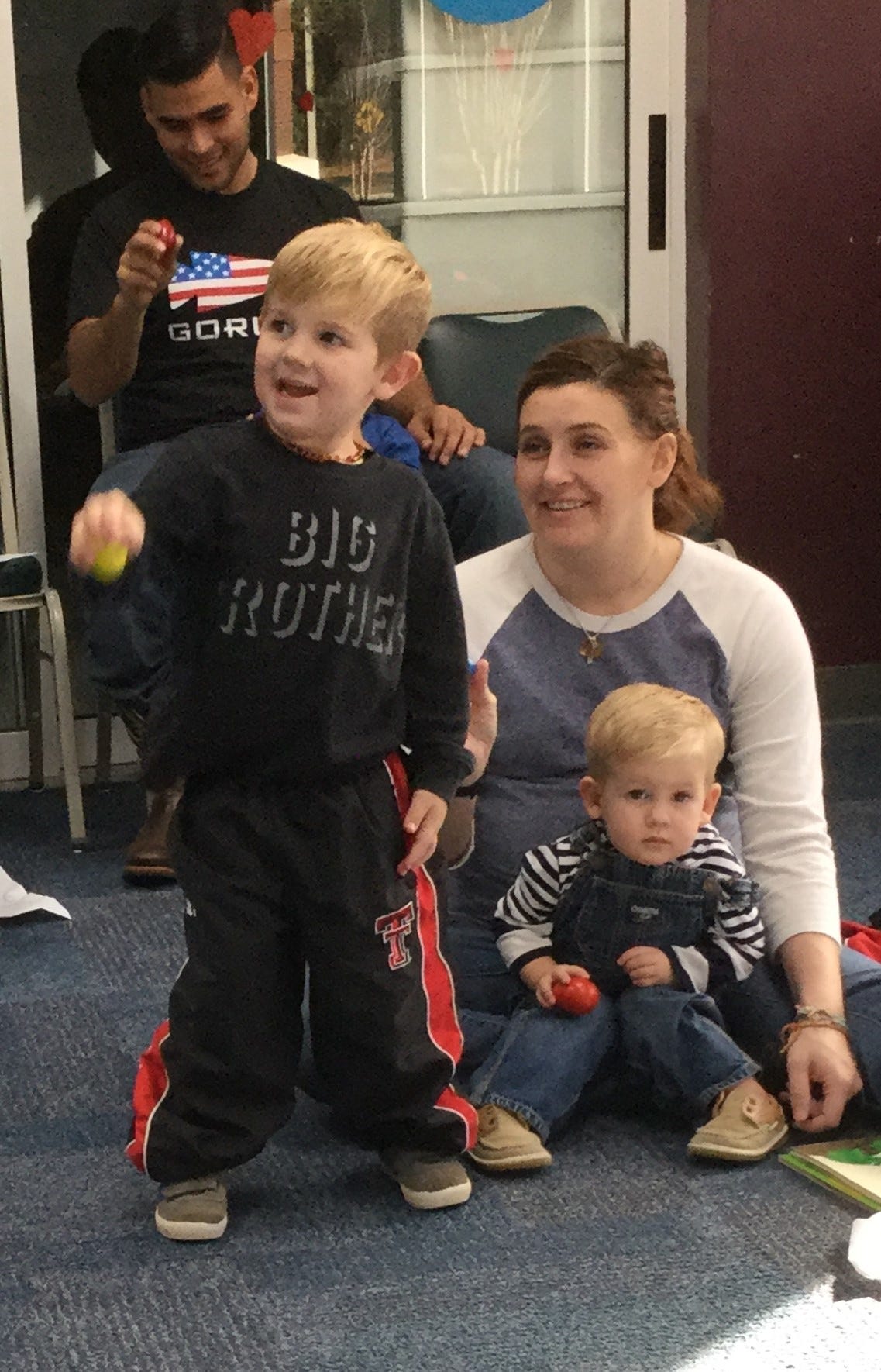 Crestview residents Luke Blair, 4, Bailey Blair, and Link Blair, 1, shake eggs up and down to Laurie Berkner's "I Know a Chicken" at Library Class Jan. 12 in Crestview. [HEATHER NITZEL | SPECIAL TO THE NEWS BULLETIN]