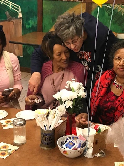 Ernestine "Dean" Edmunds, center, gets a hug from an attendee at her retirement party. [SPECIAL TO THE NEWS BULLETIN]