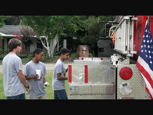 Troop 532 Boy Scouts Michael Barlow, Dillon Fredericks and Aaryn Cooper peer inside a Holt fire engine on display Monday in the First Baptist Church of Holt parking lot. The scouts, the Holt Volunteer Fire Department and the Crestview Community Emergency Response Team will collaborate for emergencies.