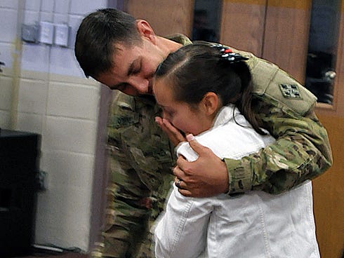 U.S. Army Pfc. Davis Schmitz embraces his 14-year-old sister, Karly Celano, after surprising her Tuesday morning in the Crestview High School band room. Schmitz recently returned from serving nearly seven months in Afghanistan.