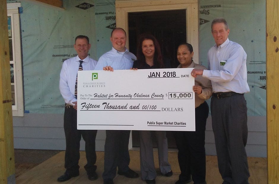 From left, Kelly Arnette, Charlie Kessler, Nitsi Bennett, Kaneichawa Smith and Terry Bennett, display a check from Publix for a house being built by Habitat for Humanity in Okaloosa County. [AARON JACOBS | NEWS BULLETIN]