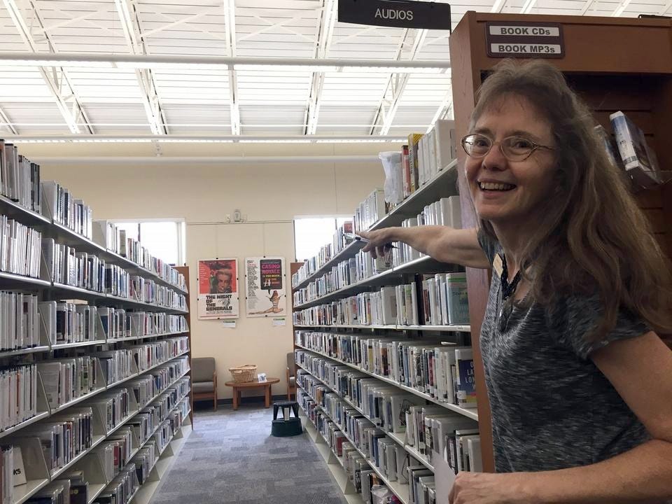 Sandra Dreaden points down an aisle of books in August, 2017 in Crestview. [FILE PHOTO | NEWS BULLETIN]