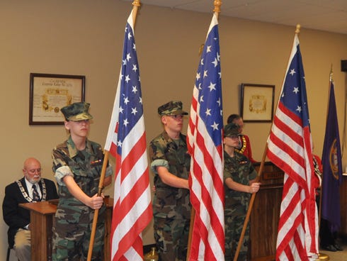 Pvt. Gwen Pepper, Lance Cpl. Rollin Cluff and Pvt. Michelle Pepper of the Emerald Coast Young Marines display the American flag’s evolution during a belated Flag Day ceremony on Saturday at the Elks Lodge in Crestview.