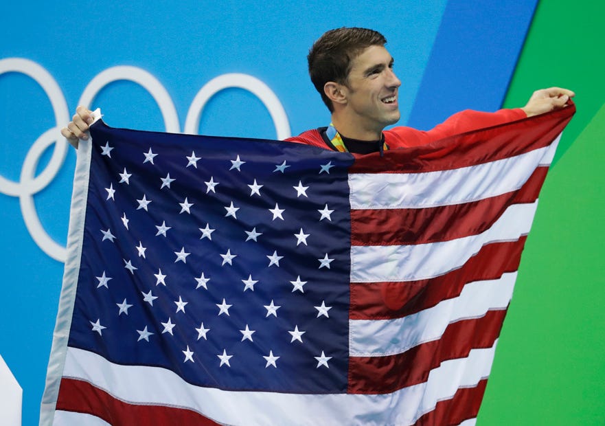 United States' Michael Phelps walks with his national flag during the medal ceremony for the men's 4- by 100-meter medley relay final during the swimming competitions at the 2016 Summer Olympics, Sunday, Aug. 14, 2016, in Rio de Janeiro, Brazil.