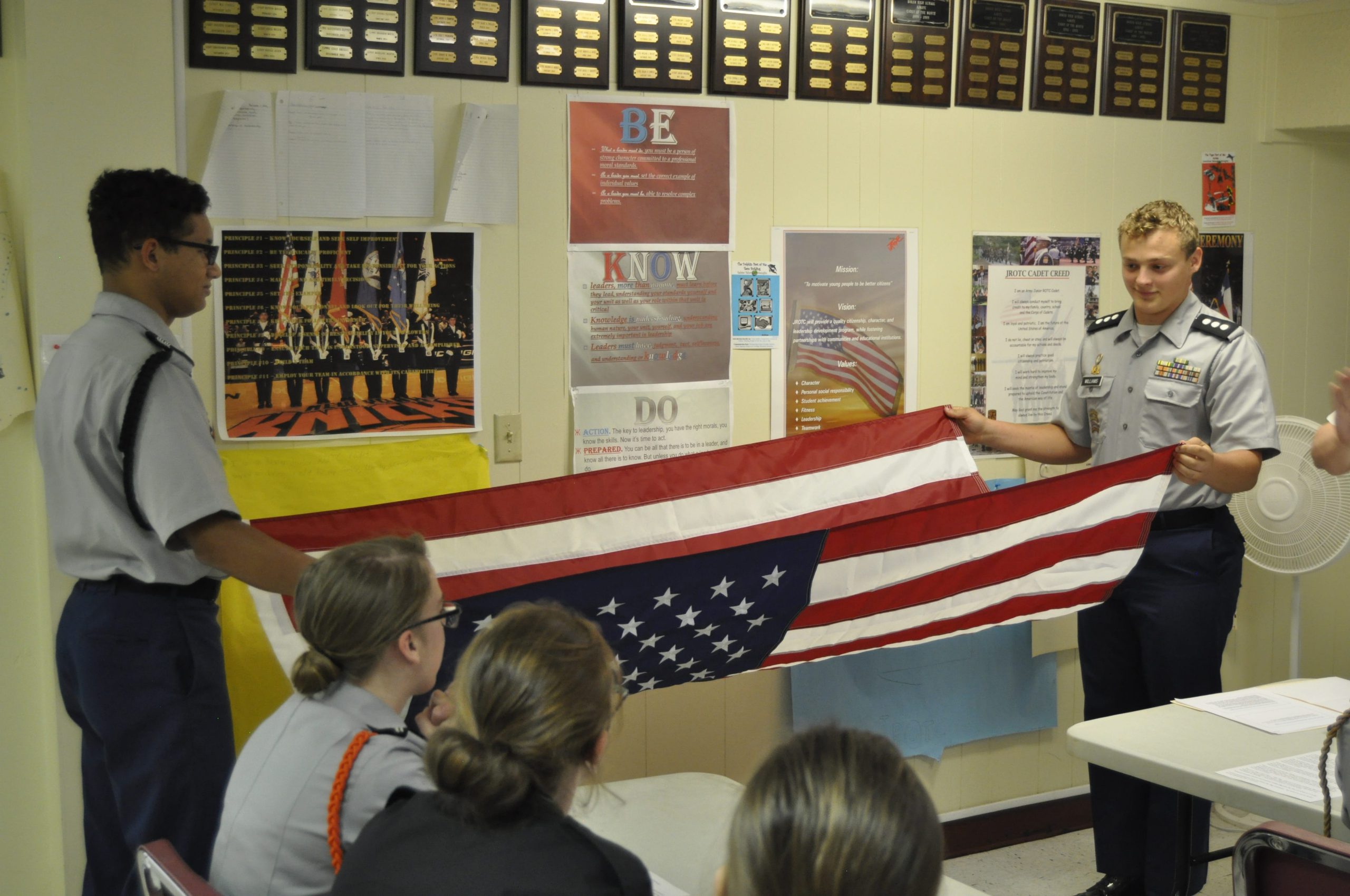 Baker JROTC students Aaron Cooper (left) and Kenny Williams demonstrate how to properly fold an American flag. [AARON JACOBS|NEWS BULLETIN]