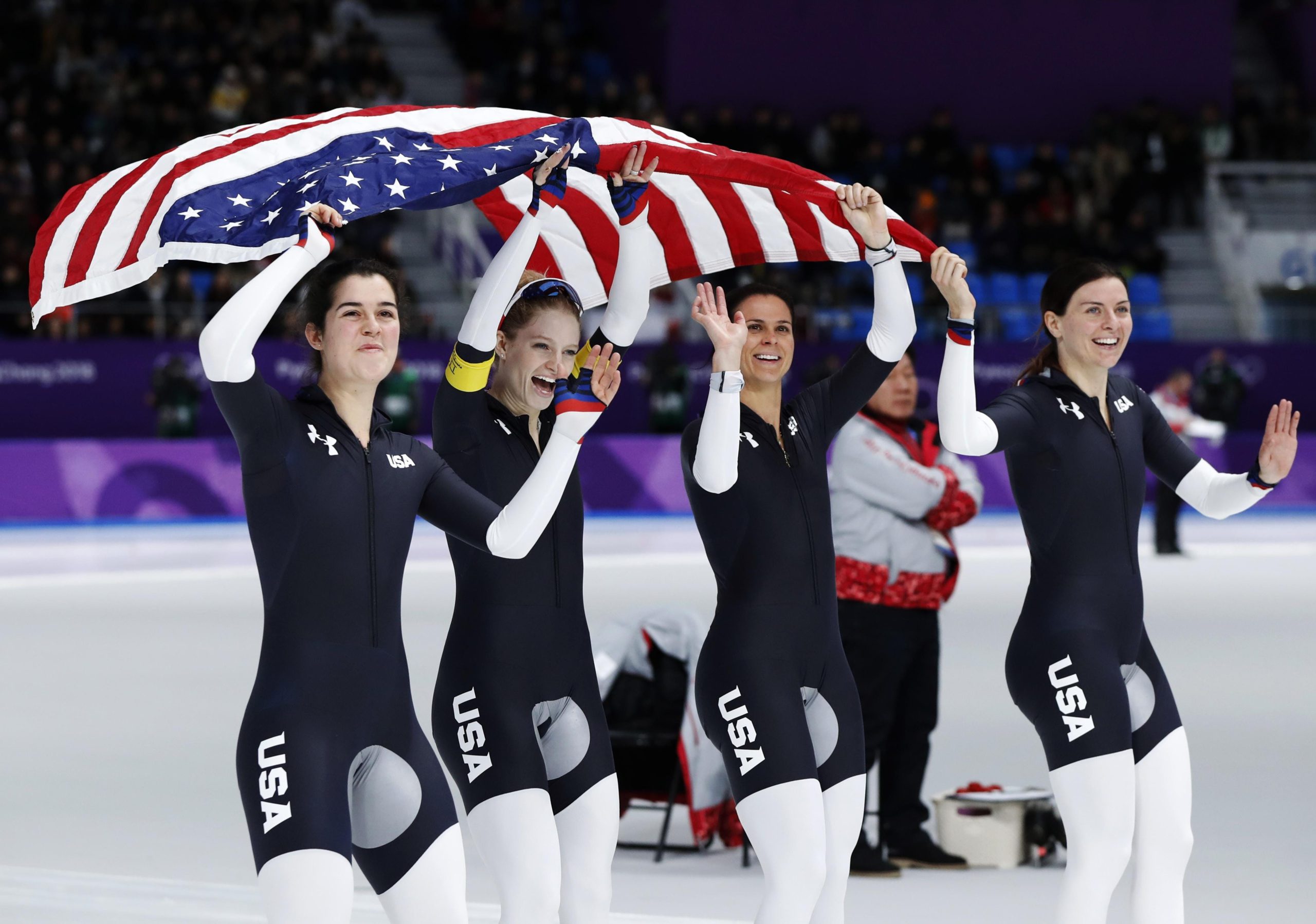 Bronze medalist team U.S.A. with Carlijn Schoutens, Mia Manganello, Brittany Bowe and Heather Bergsma, from left to right, celebrate after the women's team pursuit speedskating race at the Gangneung Oval at the 2018 Winter Olympics in Gangneung, South Korea, Wednesday, Feb. 21, 2018. [AP PHOTO/PETR DAVID JOSEK]