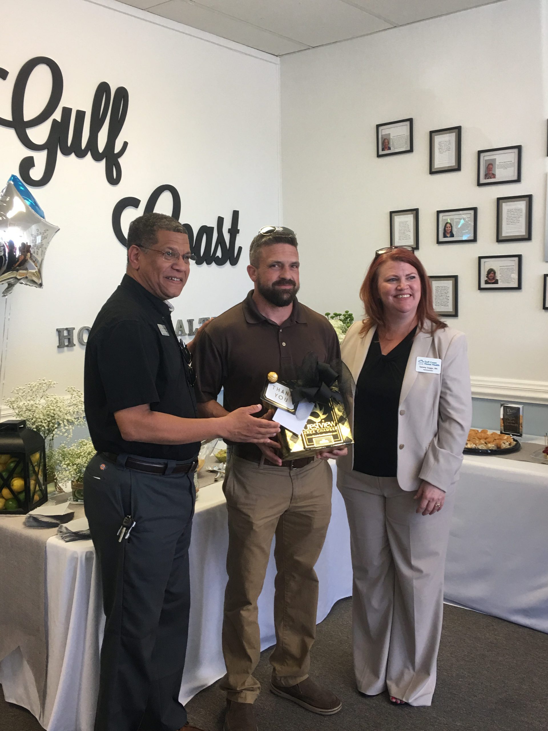 Alex Barthe (left) presents a gift on behalf of the Crestview Area Chamber of Commerce to Dr. Joshua Kolmetz (center) and Tammy Suggs, the administrator for Gulf Coast Home Health. [SPECIAL TO THE NEWS BULLETIN]