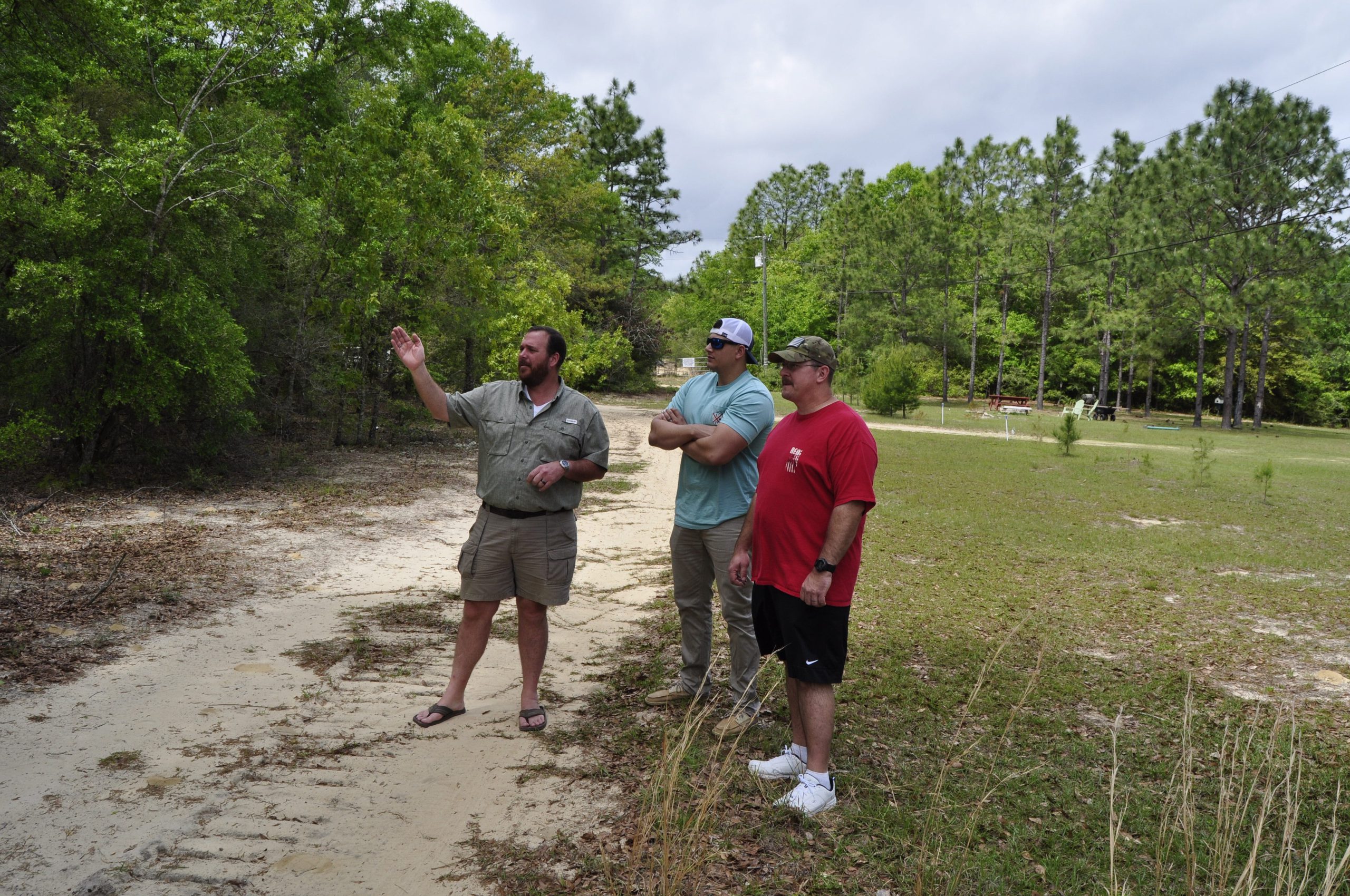 Mark Anderson (left) talks to his son, Michael Anderson (center), and neighbor Daniel Rhodes about the site of the proposed shooting range near their homes. [AARON JACOBS|NEWS BULLETIN]