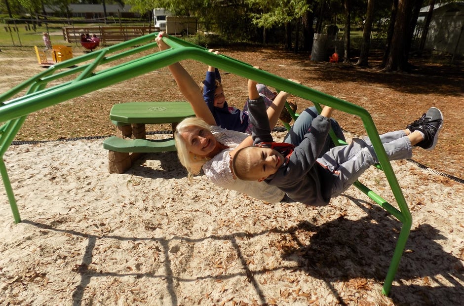 Clara Rushing (back) and Noxton Clinton (front) "hang out" with Wesleyan Child Care Center Director Osa Bell. [SPECIAL TO THE NEWS BULLETIN]