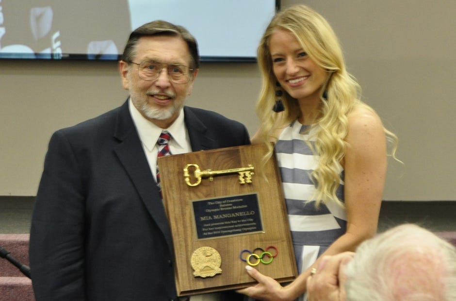 Mayor David Cadle (left) presents a key to the city to Olympic medalist and former Crestview resident Mia Manganello. [AARON JACOBS|NEWS BULLETIN]