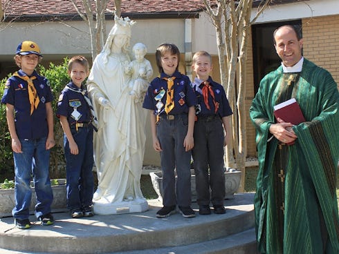 Troop 799 members Isaac Scurlock, Waylon Hopwood, Johnny Humphrey and Ben Humphrey pose with the Rev. John Cayer, pastor of Our Lady of Victory Catholic Church.