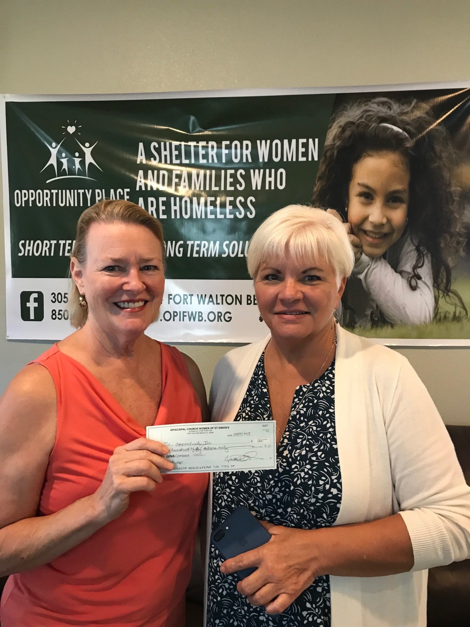 Cat Howton from St. Simon on the Sound Episcopal Church presents a $650 donation to Debra McDaniel, Executive Director of Opportunity Place, a shelter for women and families. [Special to the News Bulletin]