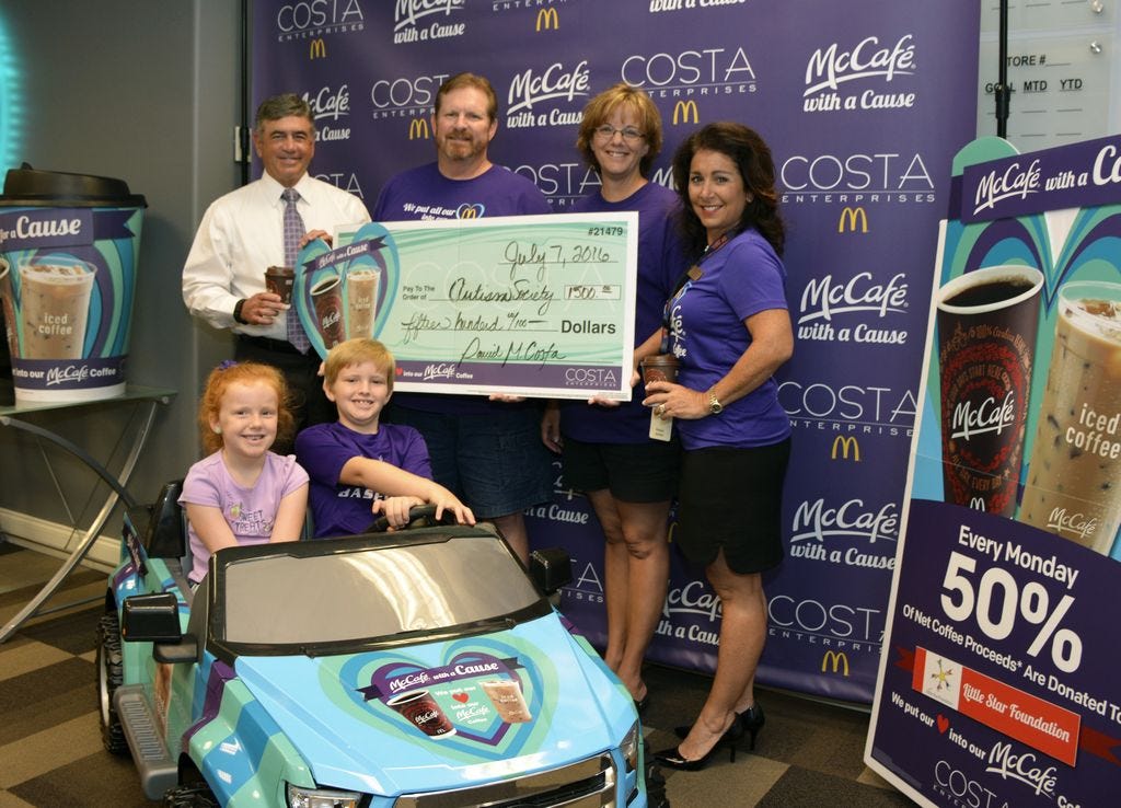 David Costa, Sr., left, and Roslyn Snyder, right, of Costa Enterprises/McDonald's present a $1,500 check to Brad and Gerrianne Burnette, center, for the Autism Society of the Emerald Coast from the Costa family McCafe with a Cause program. Driving the McCafe car are the Burnettes' children, Claire and Andrew.