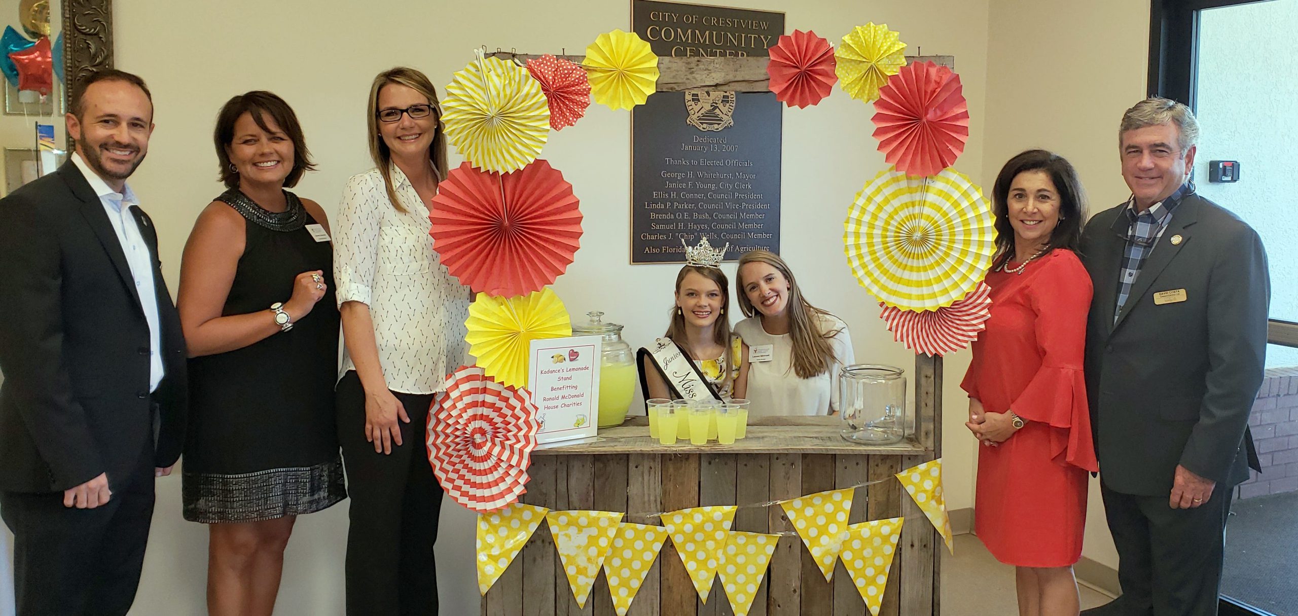 Kadance Fredericksen sits behind her lemonade stand, which she used to raise over $5,000 for the Ronald McDonald House. She is pictured with Costa Enterprises McDonald's representatives including David Costa, far right, and Ronald McDonald House associates. [SPECIAL TO THE NEWS BULLETIN]