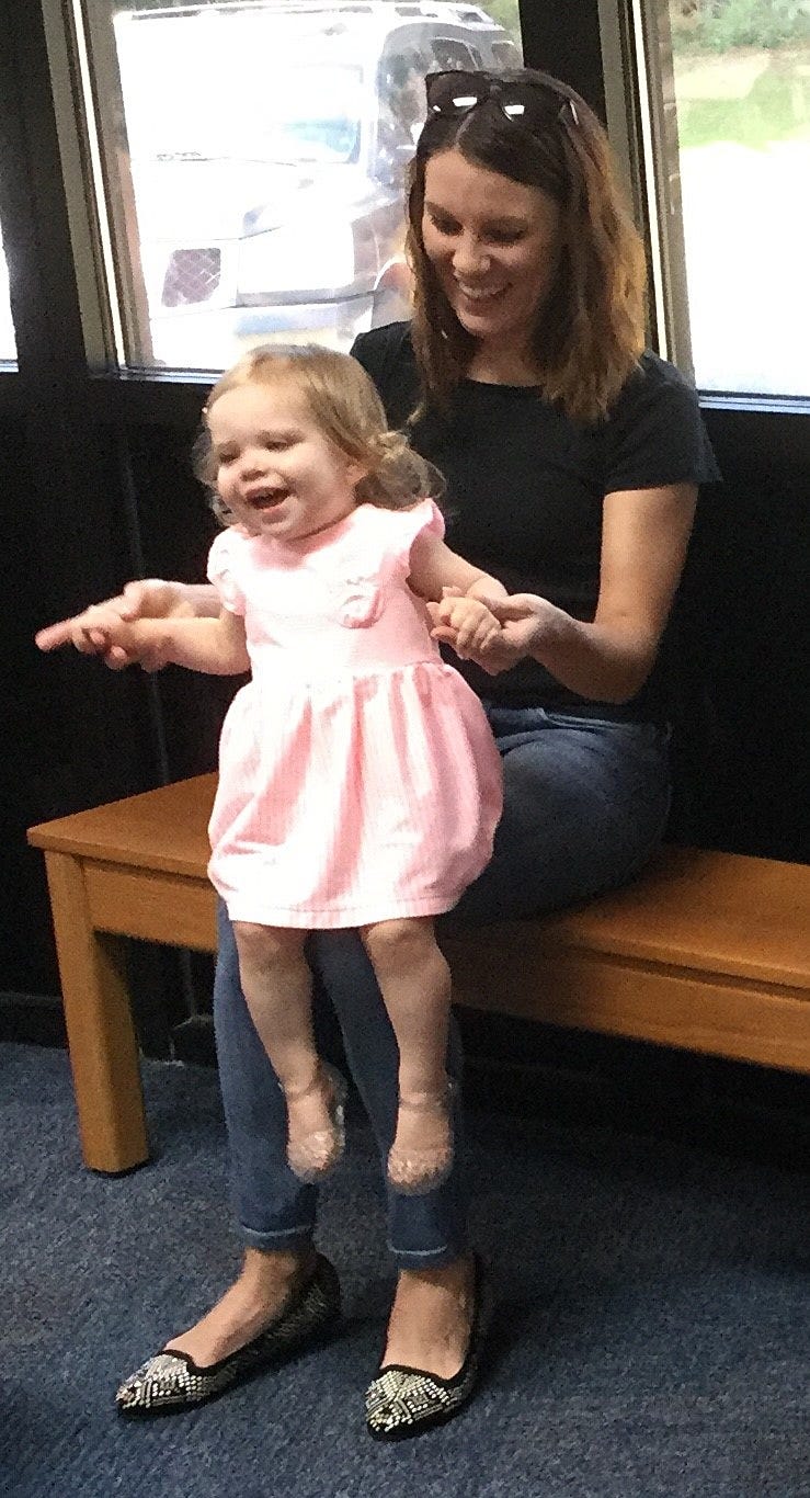 Elynn Corbett, age 1, bounces on Elisa Corbettís knee during a recent class at the Crestview Public Library. [SPECIAL TO THE NEWS BULLETIN]