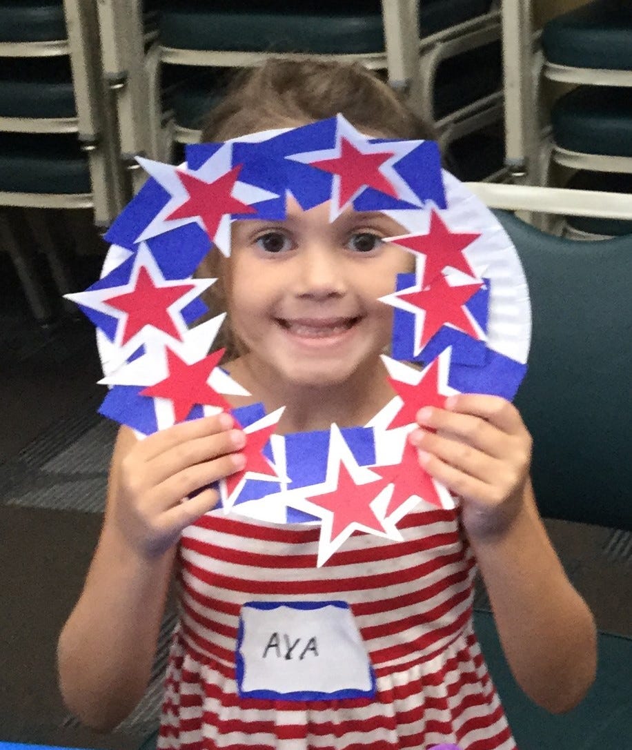 Ava MacKay, 5, holds up the patriotic wreath she made during a recent class at the Crestview Public Library. [SPECIAL TO THE NEWS BULLETIN]