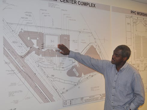 The Rev. Darrell Coleman of Praise, Power and Compassion Ministries shows plans for the church's new site, 2188 James Lee Blvd. The facility’s completion is set for December.
