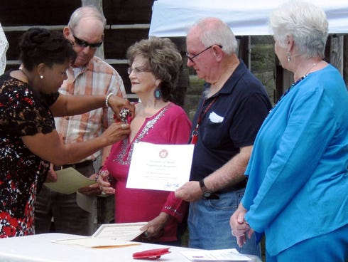 North Okaloosa Historical Association board member Phyllis Enzor pins a corsage on Dorethea Griffith as, from left, her brother Charles, board member Jerry Champion and Helen Hunt Rigdon observe. (This photo is on Page A1 of the May 21-23, 2014 edition.)