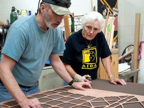 Northwest Florida State College scenic design coordinator Clint Mahle and scene shop volunteer Audrey Bailey work on a set piece for the summer musical "Les Misérables."