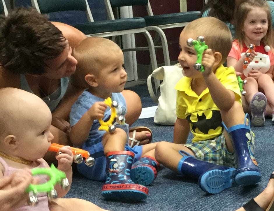 Crestview residents Amanda, Boone (age 1) and Hunter (age 2) Harrison ring bells as Library Class attendees sing recently in Crestview. [HEATHER NITZEL | SPECIAL TO THE NEWS BULLETIN]