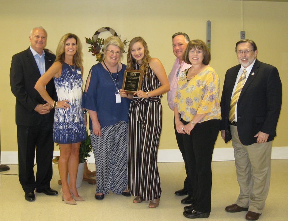 Award winner Railey Conner (center) is pictured with ceremony attendees Aug. 29 in Crestview. From left are Florida Rep. Mel Ponder; Florida Health Care Association Director of Communications Kristen Knapp; Okaloosa County School Superintendent Mary Beth Jackson; Okaloosa School Board member Tim Bryant; Crestview Rehabilitation Administrator Renita Infinger, and Crestview Mayor David Cadle. [RENEE BELL | NEWS BULLETIN]
