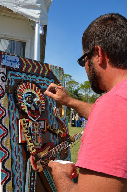 An artist adds touches to artwork during a previous Annual Festival of the Arts.