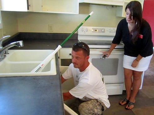 Volunteers Sam Nimmo and Miriama Devine assess necessary repairs in the Steele family’s kitchen.