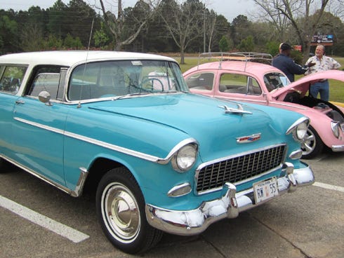 An early 1960s Volkswagen Beetle flanks a 1955 Chevrolet Bel Air station wagon during the car show.