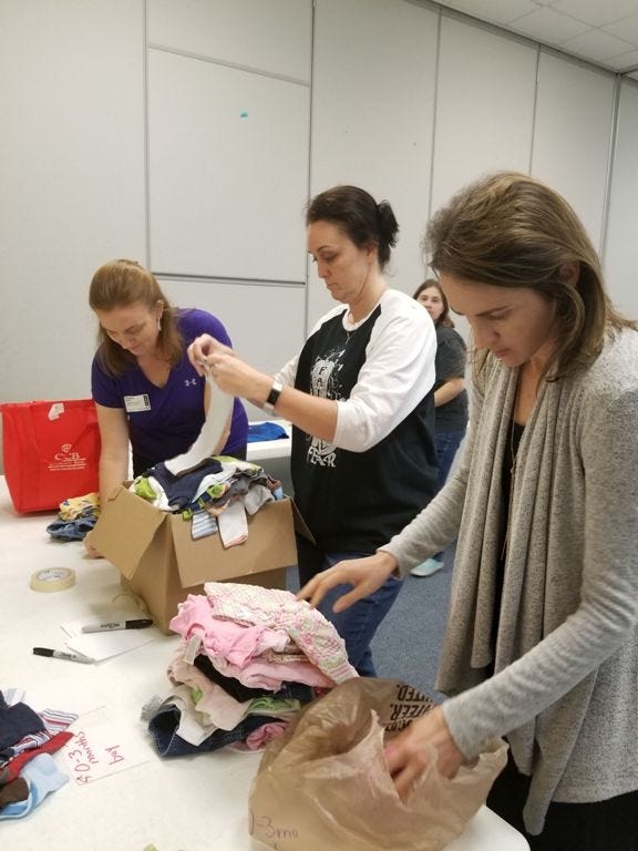 Members of Emmanuel Baptist Church sort through clothes for foster families during their small group session. This was one of many times the church has served foster and adoptive families in Crestview. [CONTRIBUTED PHOTO]