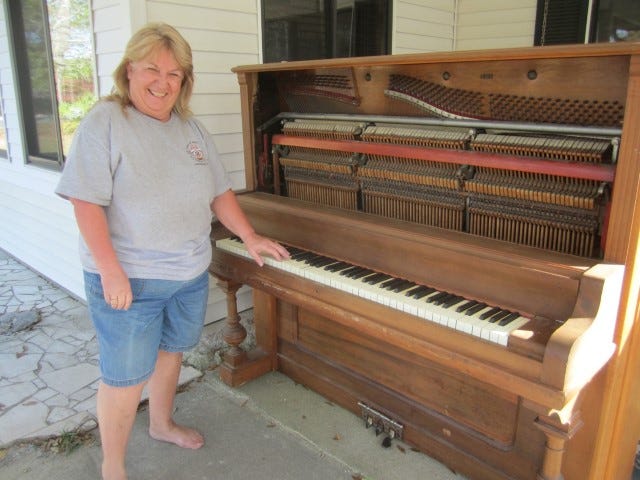 Emily Sanders tickles the ivories on an old piano that raised neighbors' eyebrows when she set it out by the street.