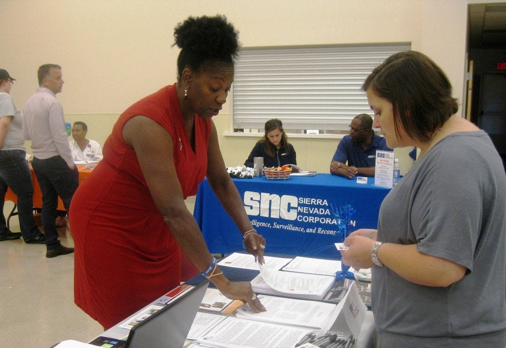 Troops to Teachers recruiter Carolyn Sutton selects information for Nicki Ogle, whose husband is about to separate from the Army and, she said, would make an “awesome” teacher.
