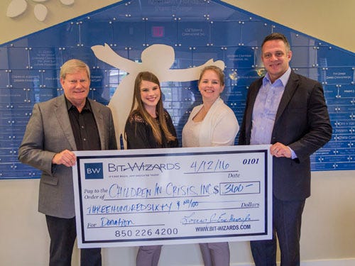 Children in Crisis representatives accept a $360 donation from Bit Wizards officials. The funds will be used to provide summer vacation activities to CIC children. From left are CIC President and CEO Ken Hair, CIC Development Director Allie Noah, Bit Wizards Marketing Director Candace Mitchell and Bit Wizards Chief Operating Officer Louis J. Erickson Jr.